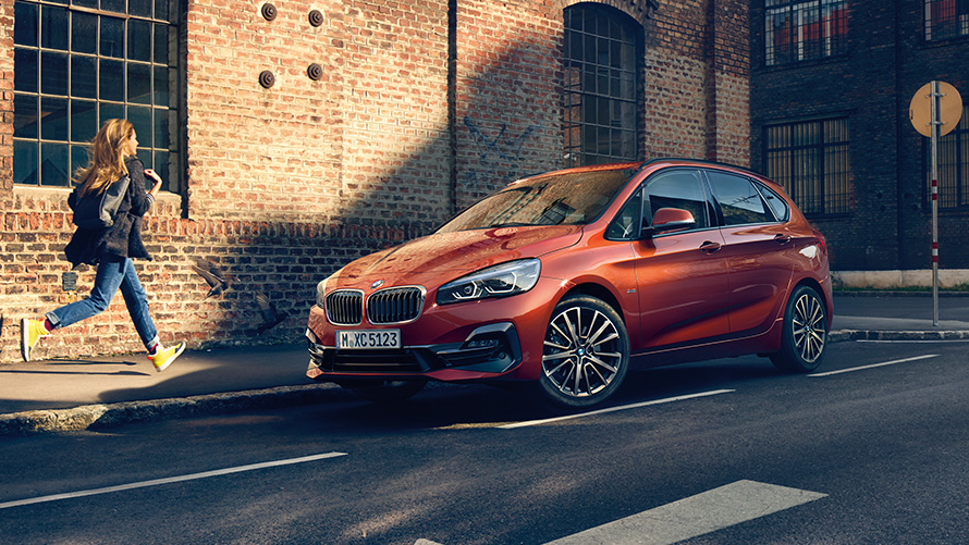 BMW 2 Series Active Tourer F45 three-quarter side view driving on the street BMW 2 Series BMW 2 Series Active Tourer F45 three-quarter side view driving on the street