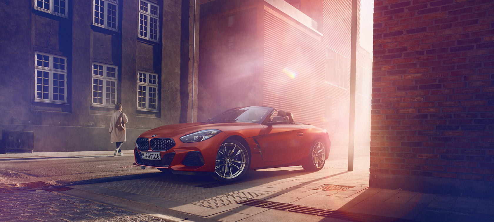 Orange BMW Z4 First Edition on street Orange BMW Z4 First Edition on half-light street in front of houses with women
