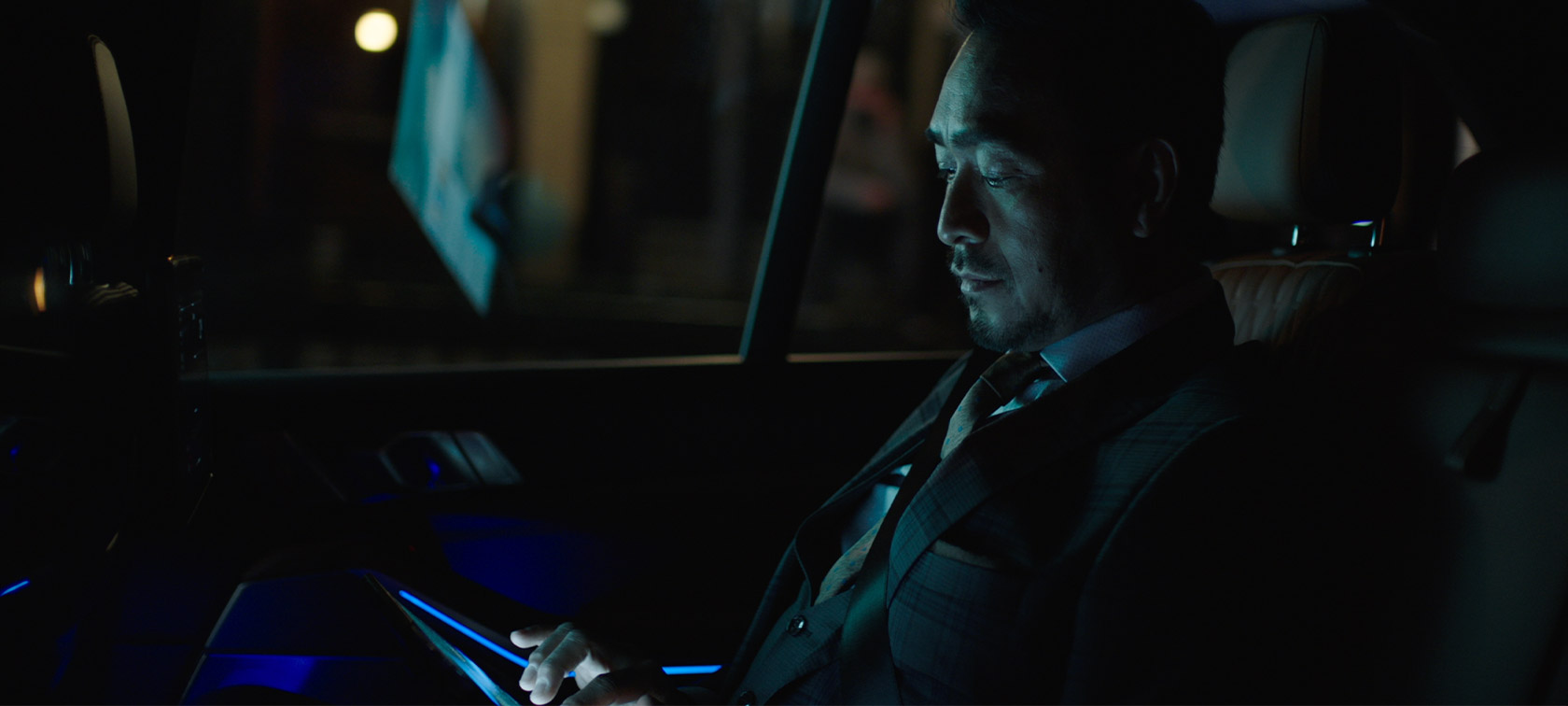 Man riding in back of BMW at night